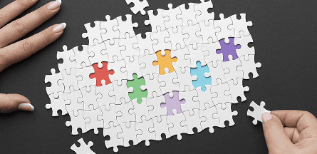 White and solid color puzzle pieces. Puzzle is mostly assembled, with a few loose pieces, missing spaces.