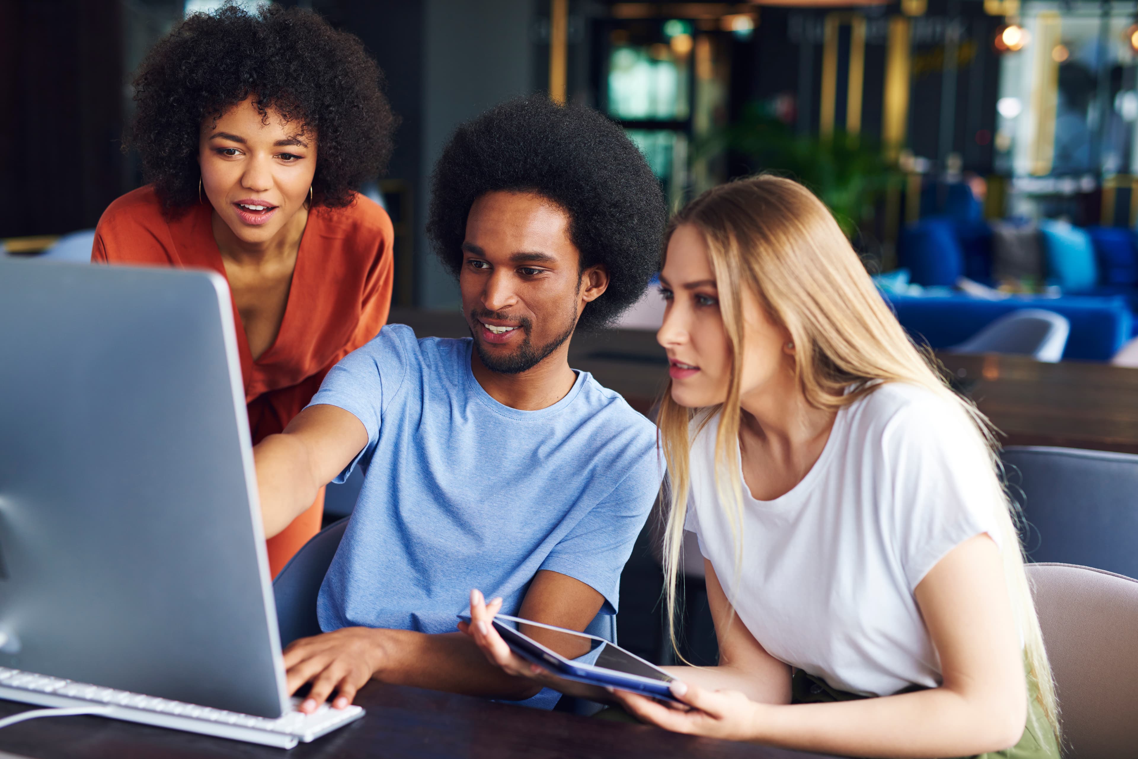 three individuals looking at a computer screen